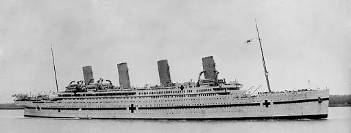 A large cruise ship with four sails and two crosses on the side.