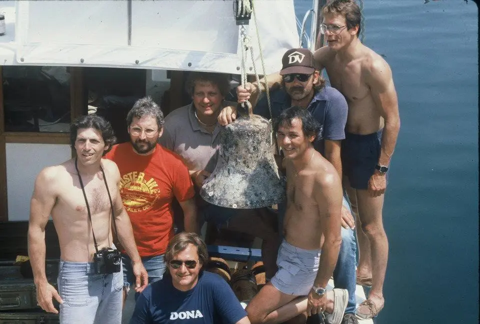 A group of people standing on top of a boat.