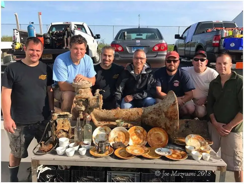 A group of men sitting around a table with food.