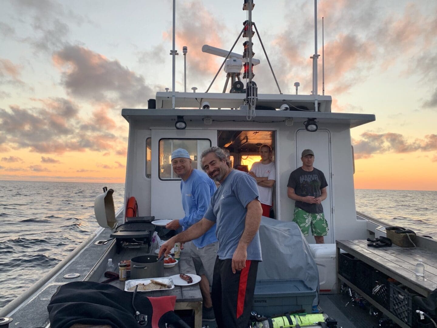 A group of people standing on the back of a boat.