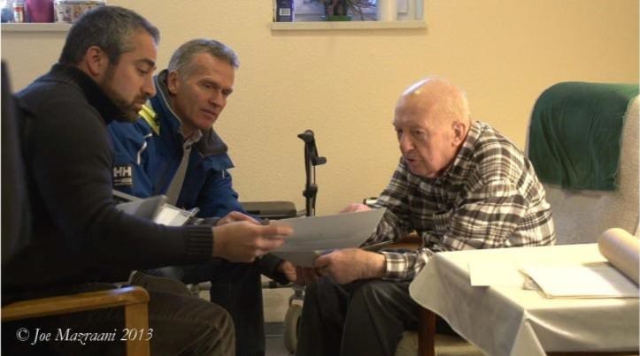 A group of men sitting around each other.