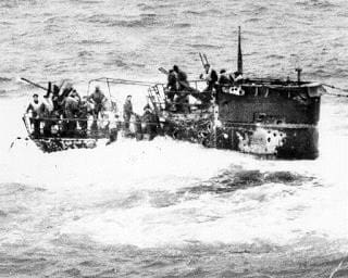 A group of people standing on top of a boat.