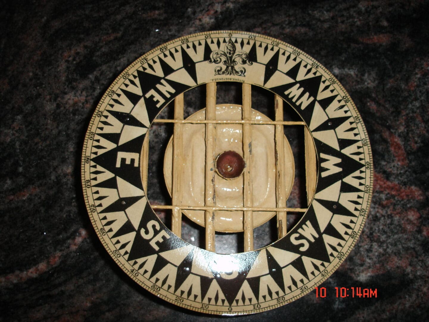 A compass with a cage on top of it.