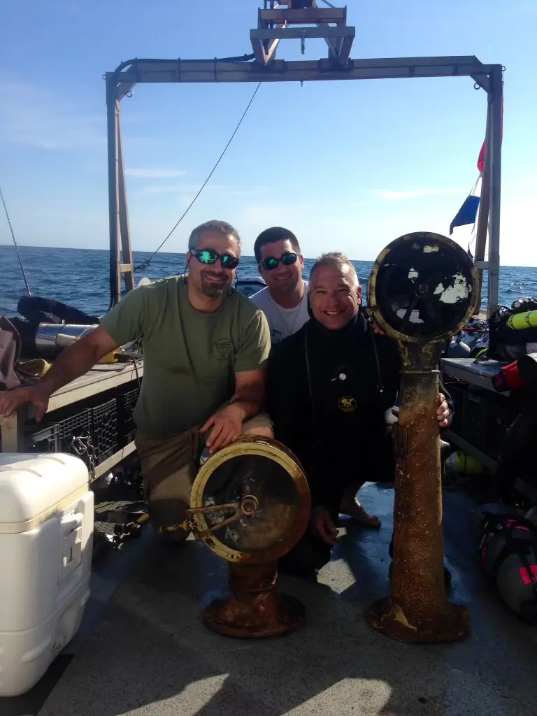 Three men on a boat with their gear.