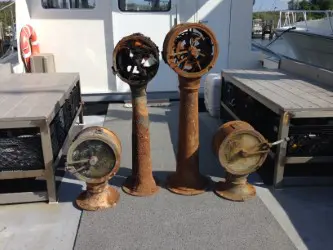 Four old fashioned fire hydrants are sitting on the deck.