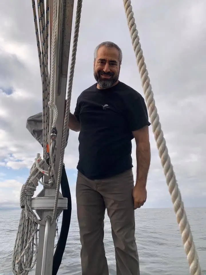 A man standing on the side of a boat.