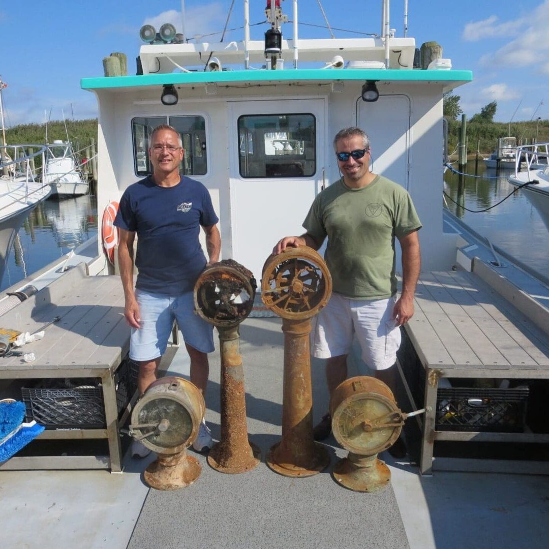 Two men standing on the deck of a boat.