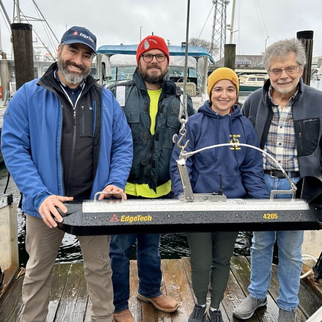 A group of people standing on top of a dock.